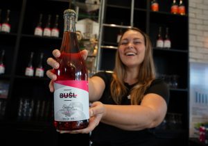 holding a bottle of cider at busl