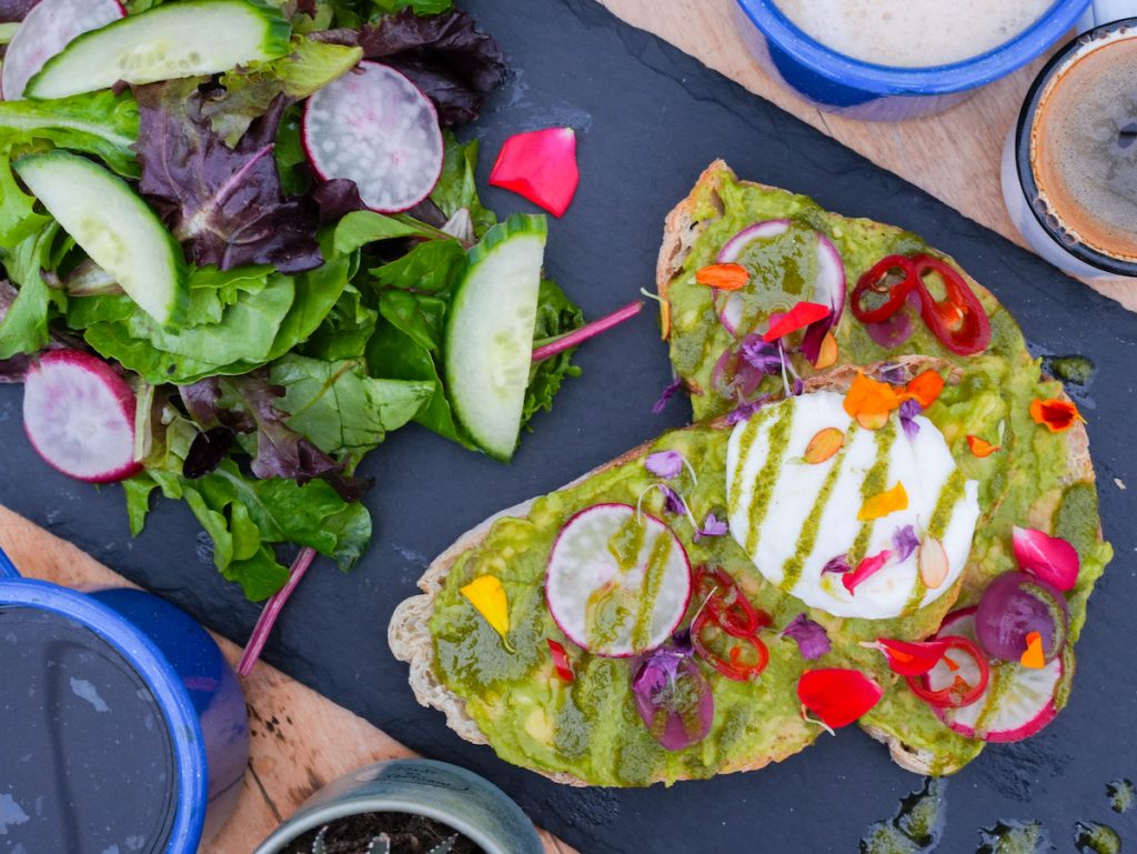 overhead shot of avocado toast and salad at the watering can
