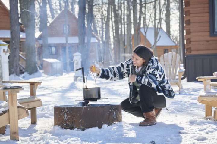 Aicha cooking over a campfire