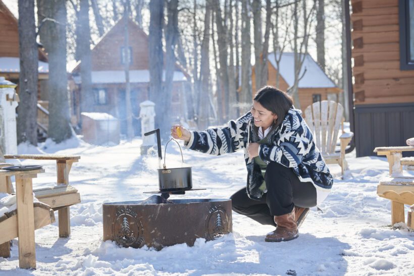 Aicha cooking over a campfire