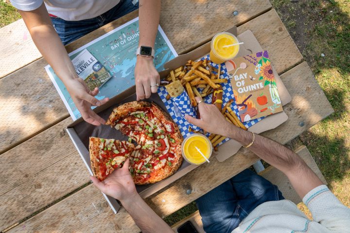 an overhead shot of all the food we got at pop ups on the bay for pizza, fries and bay of quinte magazine