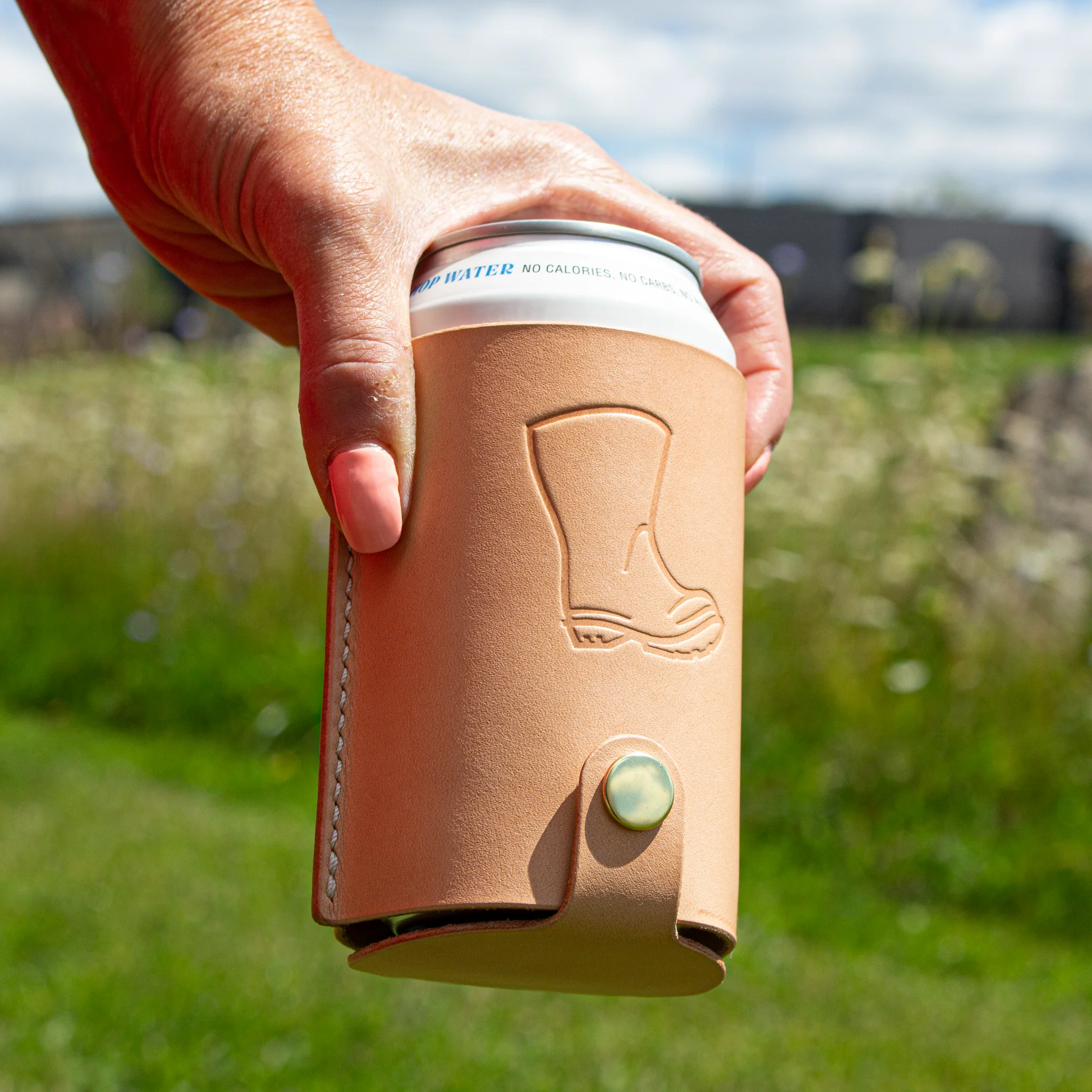 leather koozie holding a beer from wellington