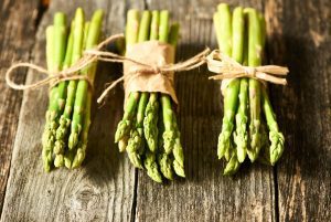 close up of three bunches of asparagus tied with twine