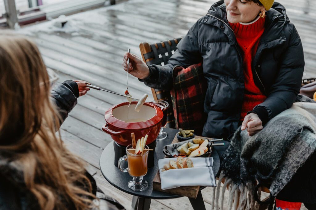 two women dipping fondue out on the patio at The Drake Devonshire