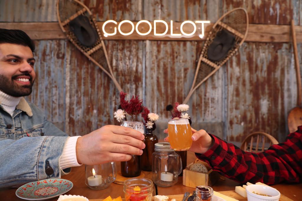 Two people cheersing their beers at GoodLot