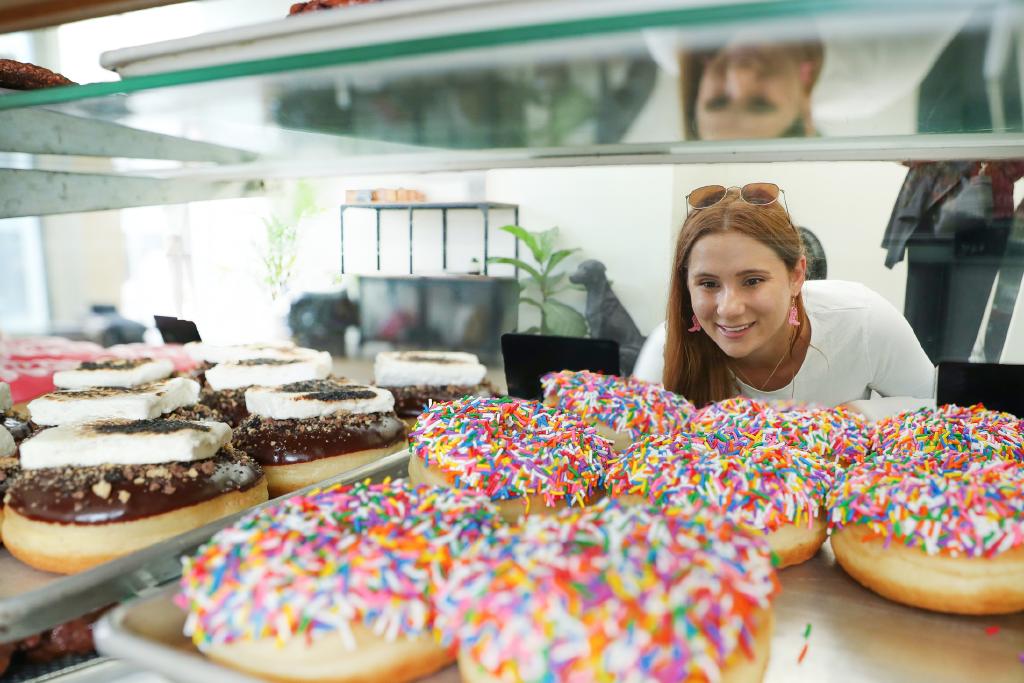 girl looking at a case of donuts at Little Thief Bakery
