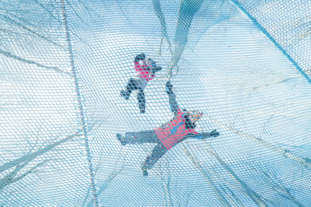 laying on a mesh net in the trees at Tree Top Trekking