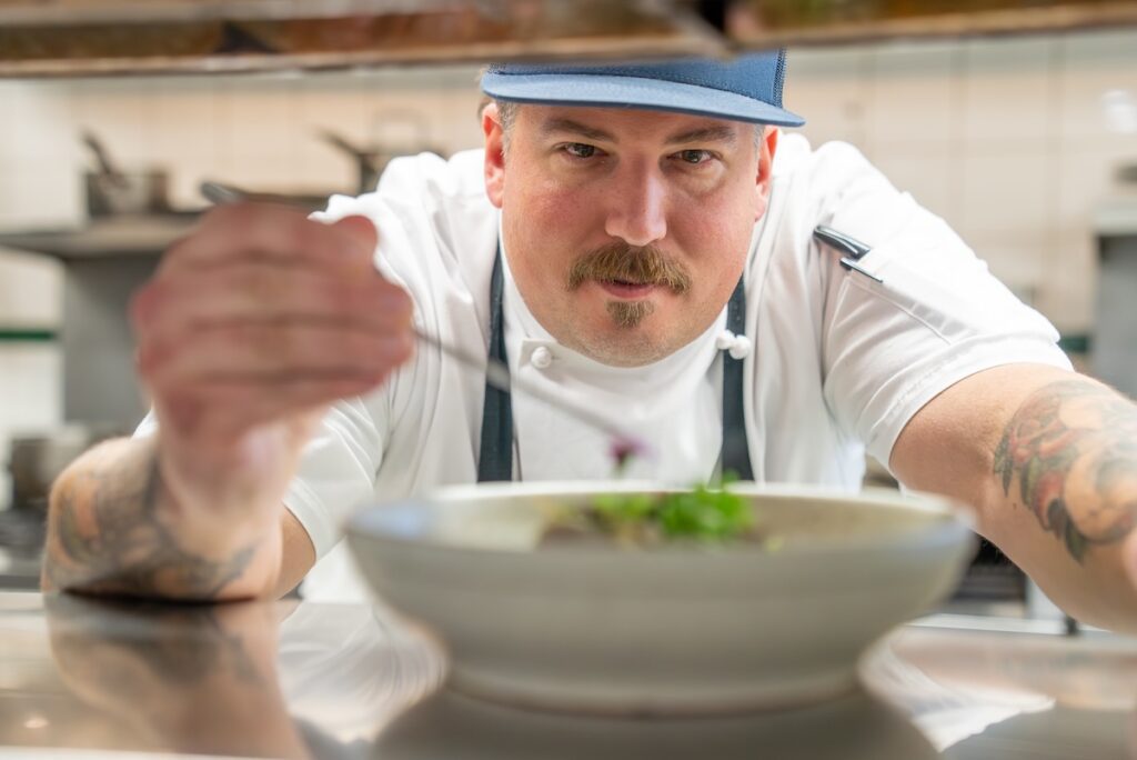 Chef George Ward adding last minute touches to a dish with tweezers