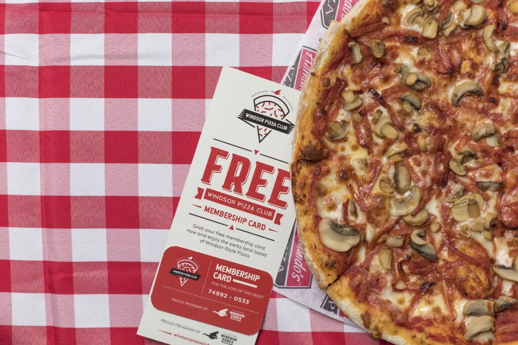 overhead shot of pizza and Windsor Pizza Club tag