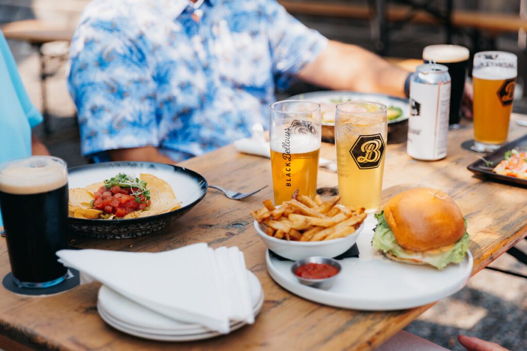 black bellows brewing company spread on table with burger, beer and more
