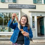 T pulling apart a chimney cake in front of Budapest Bake Shop