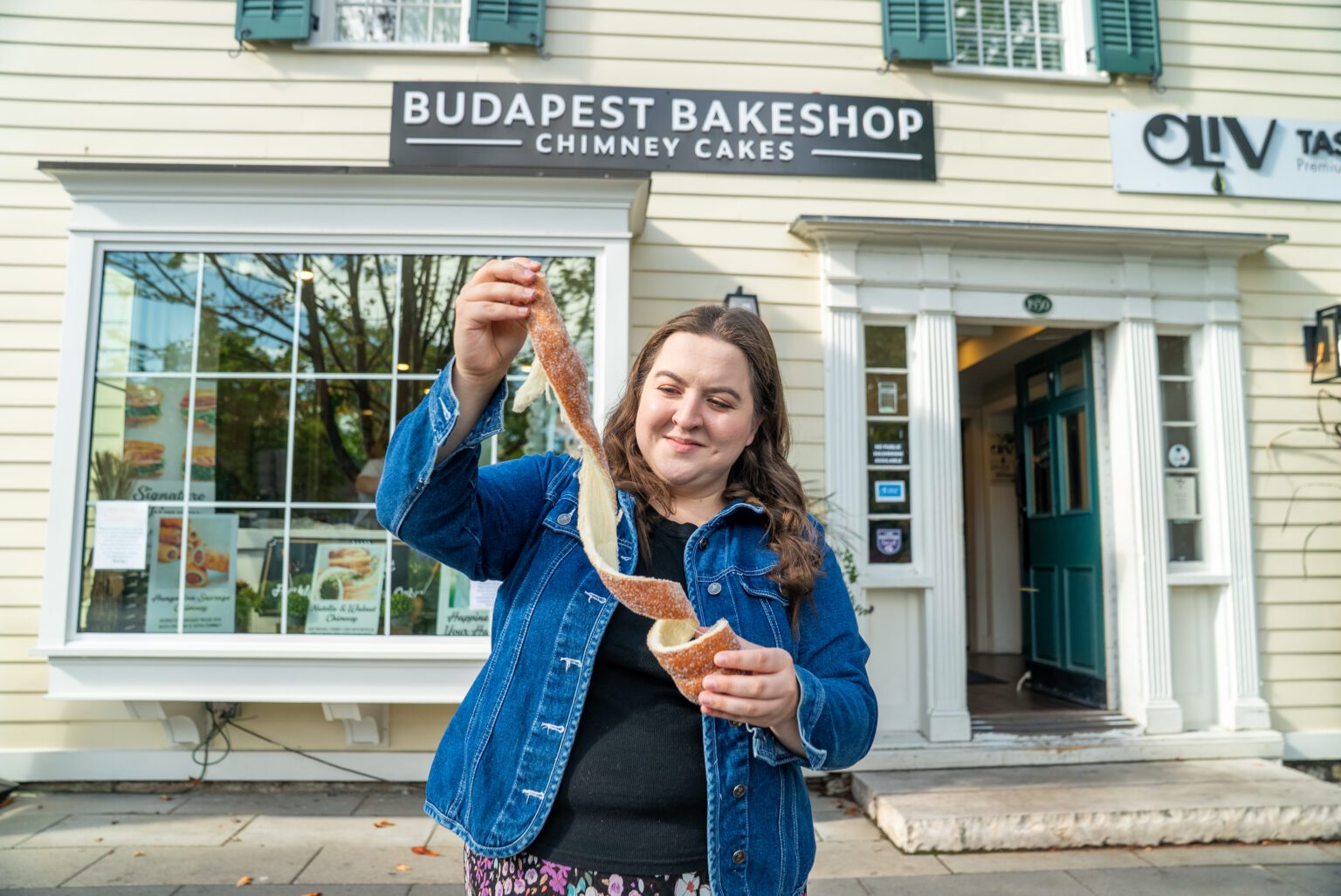 T pulling apart a chimney cake in front of Budapest Bake Shop