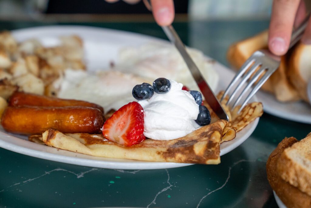 fork and knife cutting into a crepe