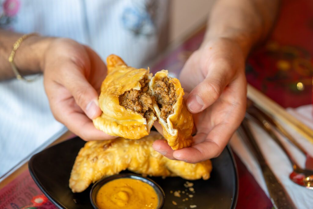 savoury hand pie being split in half by hand
