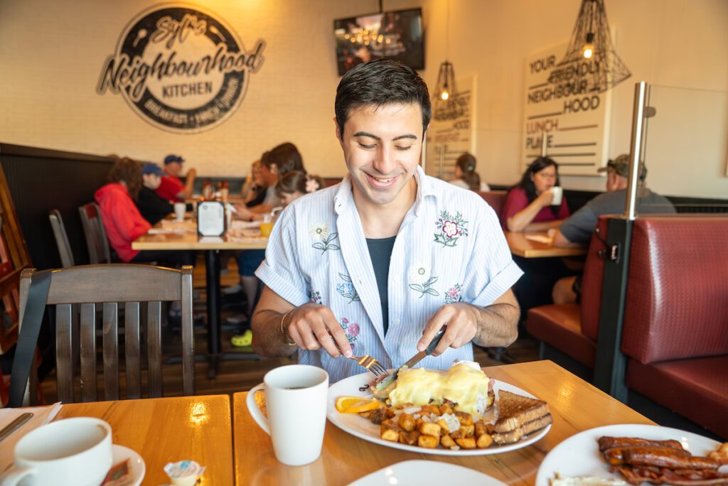Zain cutting into eggs benedict at Syl's