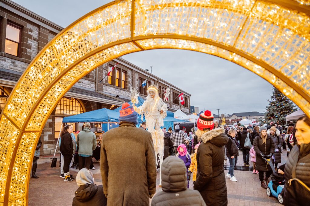 outdoor winter market in North Bay with performer on stilts