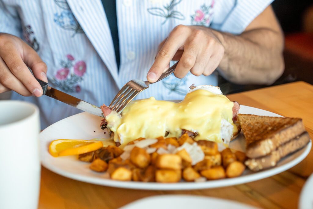 Cutting into eggs benedict at Syl's