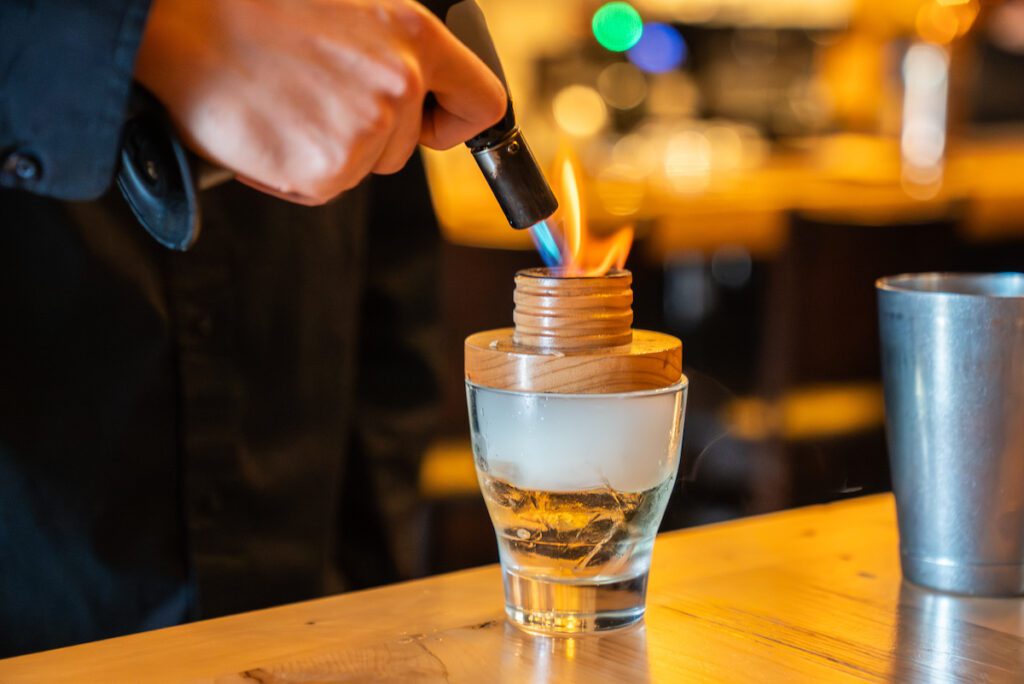 close up of a brulee torch over a cocktail at The Block Public House