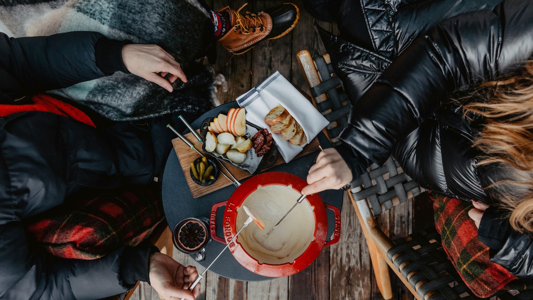 overhead shot of two hands into fondue at Drake Devonshire