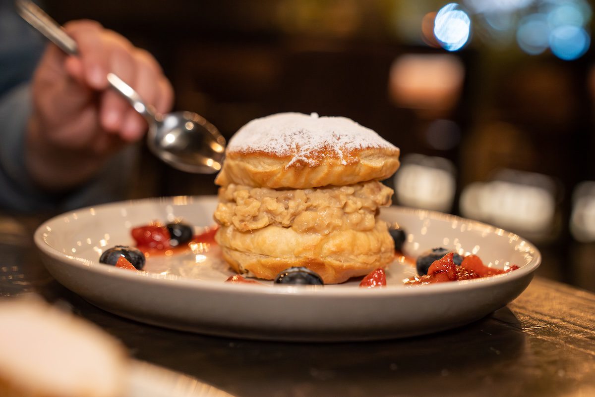 fork and knife about to cut into a beignet tower at Industry Social House