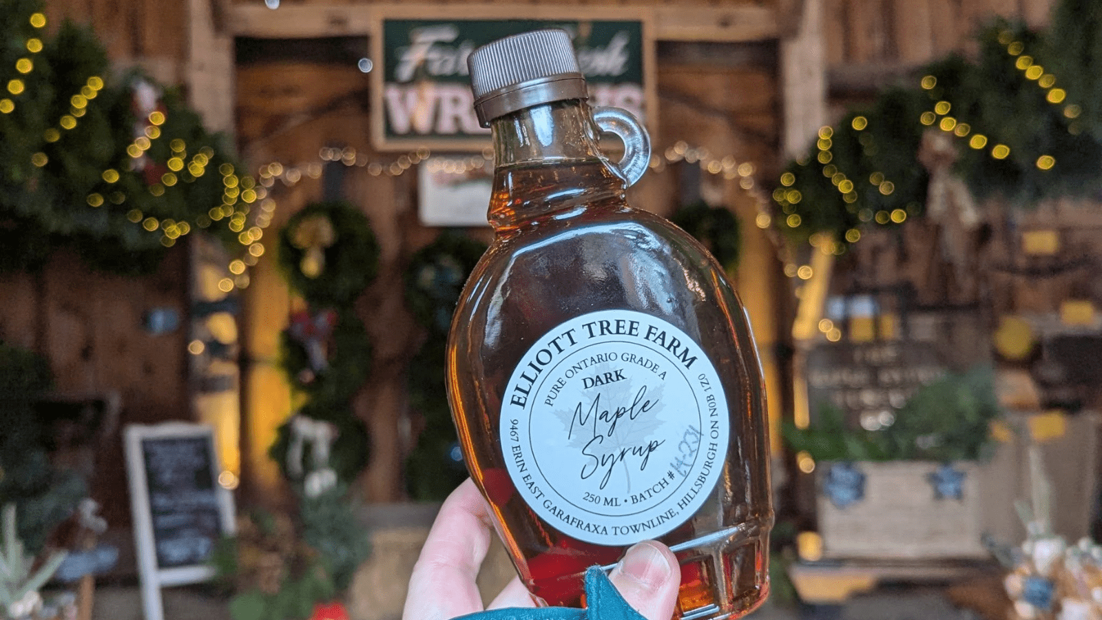 Hand holding maple syrup at Elliott Tree Farm