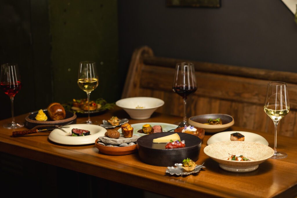 A meal with two glasses of wine laid out on the table at Down Home