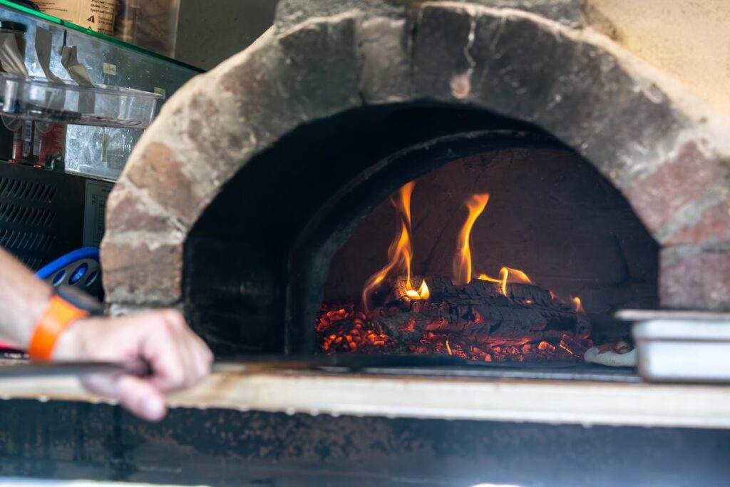 pizza peel going into oven to grab pizza at lowlands