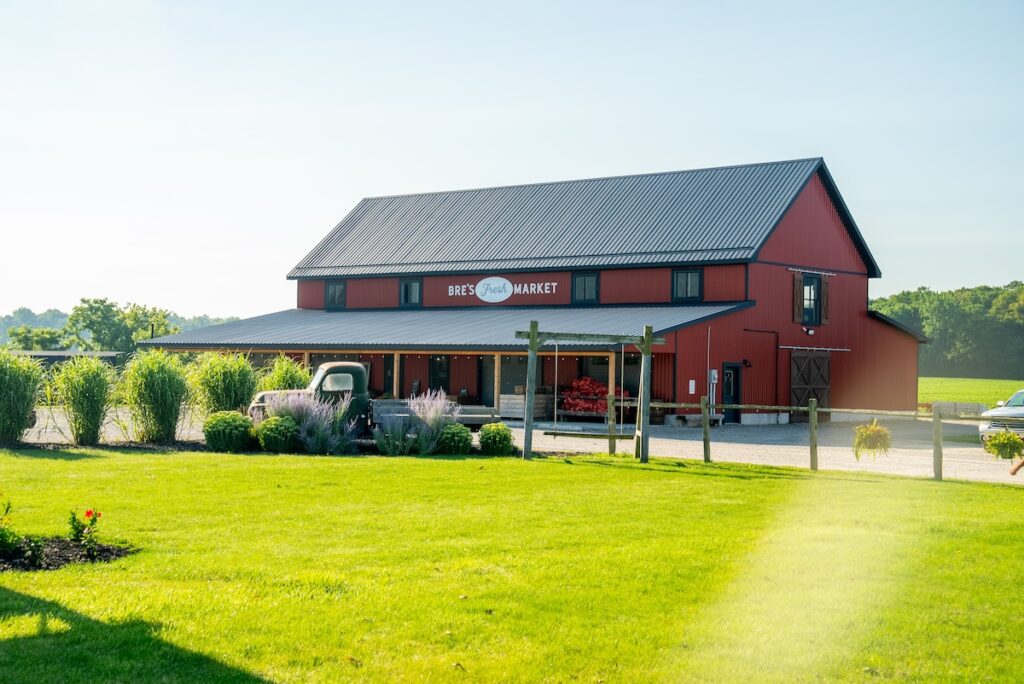 Exterior of Bre's Fresh Market on a sunny day. It's a bright ed building with a large front lawn.