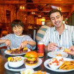 Child and adult eating dinner at the mill