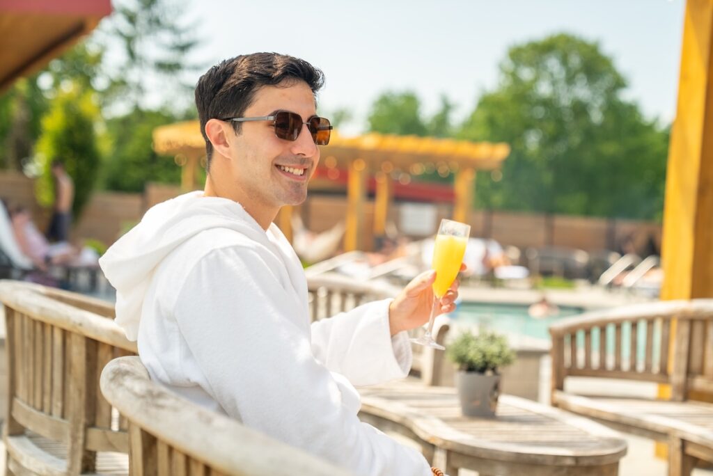 Zain drinking a mimosa in a bath robe